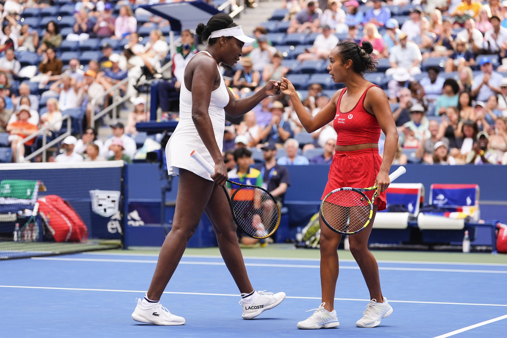 Venus Williams, of the United States, left, and Leylah Fernandez, of Canada, talk on the court during a first round women's doubles match against Lyudmyla Kichenok, of the Czech Republic and Ellen Perez, of Australia, during the U.S. Open tennis championships, Thursday, Aug. 28, 2025, in New York. (AP Photo/Yuki Iwamura)