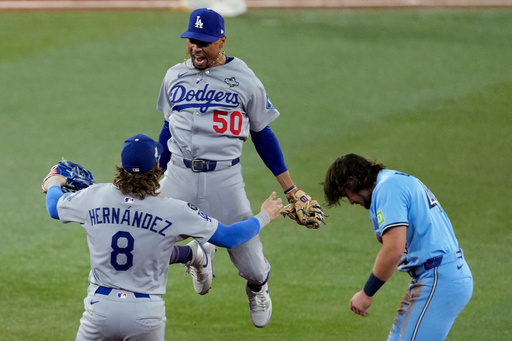 Los Angeles Dodgers' Mookie Betts (50) leaps into the arms of Kiké Hernández (8) after Toronto Blue Jays' Addison Barger, right, was forced out to end Game 6 of baseball's World Series, Friday, Oct. 31, 2025, in Toronto. (AP Photo/Ashley Landis) Los Angeles Dodgers' Mookie Betts (50) leaps into the arms of Kiké Hernández (8) after Toronto Blue Jays' Addison Barger, right, was forced out to end Game 6 of baseball's World Series, Friday, Oct. 31, 2025, in Toronto. (AP Photo/Ashley Landis)