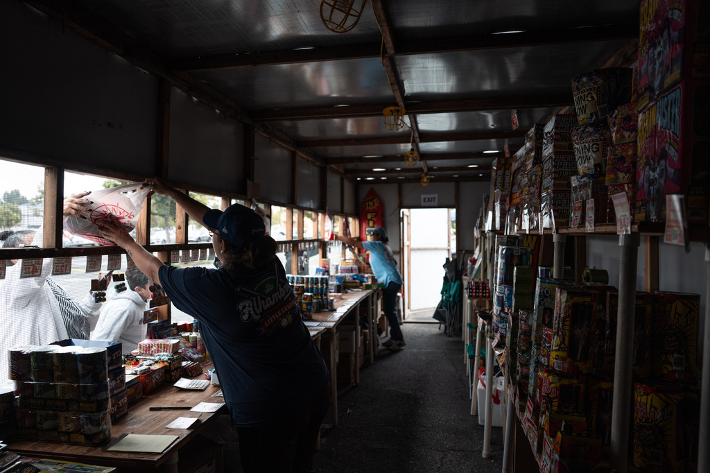 Volunteers Laurene Cardoza, front, and Jennifer Aragon work at a TNT Fireworks stand in Alhambra, Calif., Tuesday, June 30, 2026, ahead of the Fourth of July holiday. (AP Photo/Jae C. Hong)