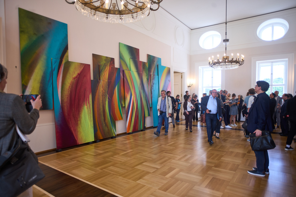 People walk in front of an untitled painting of Katharina Grosse, during the press preview of an exhibition of contemporary art at the German President's residency, Bellevue Palace, in Berlin, Germany, Monday, June 8, 2026. (AP Photo/Markus Schreiber)
