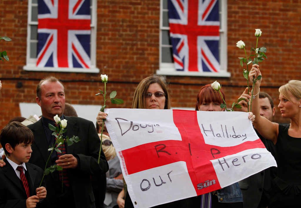 FILE - Relatives of British Army Private Douglas Halliday, of the 1st Battalion The Mercian Regiment, one of the seven British soldiers killed in Afghanistan, line a street as his coffin is driven through the town of Wootton Bassett, England, following repatriation, Tuesday, June 29, 2010. (AP Photo/Lefteris Pitarakis, file)