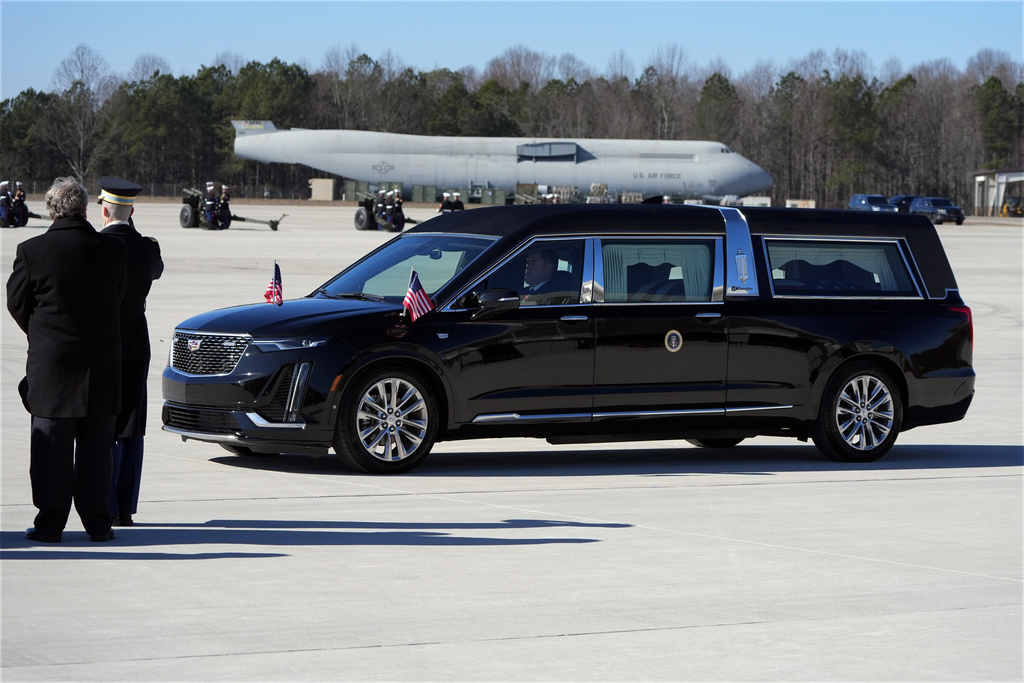 The hearse carrying the flag-draped casket of former President Jimmy Carter arrives at Dobbins Air Reserve Base in Marietta, Ga., Tuesday, Jan. 7, 2025. Carter died Dec. 29 at the age of 100. (AP Photo/Alex Brandon, Pool)