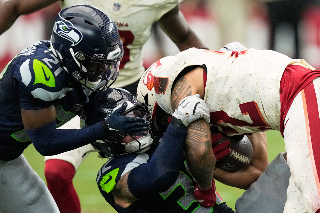 Seattle Seahawks cornerback Devon Witherspoon (21) and linebacker Drake Thomas (32) tackle Arizona Cardinals running back Tyler Allgeier (22) during the second half of an NFL football game in Glendale, Ariz., Sunday, Sept. 20, 2026. (AP Photo/Ross D. Franklin)