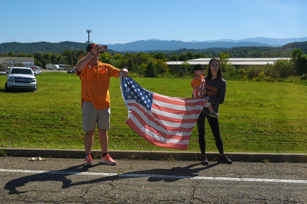 Supporters wave an American flag as a motorcade for President Donald Trump departs from McGhee Tyson Airport, Saturday, Sept. 26, 2026, in Alcoa, Tenn. (AP Photo/Julia Demaree Nikhinson)