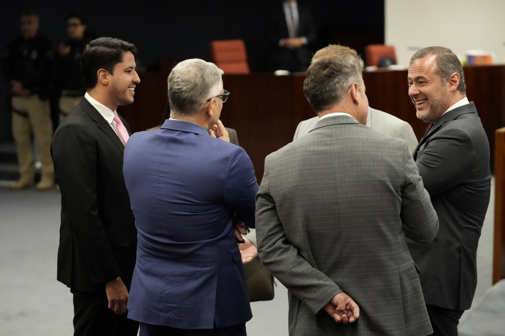 Paulo Bueno, the lawyer of former President Jair Bolsonaro, right, talks with other lawyers before the start of the verdict and sentencing phase of a trial for those charged in an alleged coup plot to keep former President Jair Bolsonaro in office after his 2022 election defeat, in Brasilia, Brazil, Tuesday, Sept. 9, 2025. (AP Photo/Eraldo Peres)