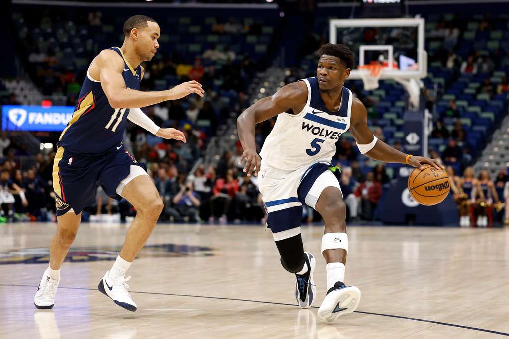 Minnesota Timberwolves guard Anthony Edwards (5) drives to the basket as New Orleans Pelicans guard Bryce McGowens (11) defends in the first half of an NBA basketball game, in New Orleans, Tuesday, Dec. 2, 2025. (AP Photo/Tyler Kaufman)