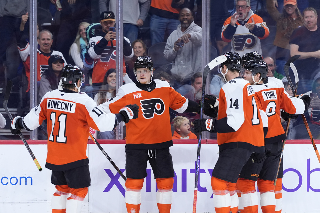 Philadelphia Flyers' Owen Tippett (74) celebrates with Philadelphia Flyers' Travis Konecny (11), Sean Couturier (14) and Cam York (8) after scoring a goal during the second period of an NHL hockey game against the Seattle Kraken Monday, Oct. 20, 2025, in Philadelphia. (AP Photo/Matt Slocum)