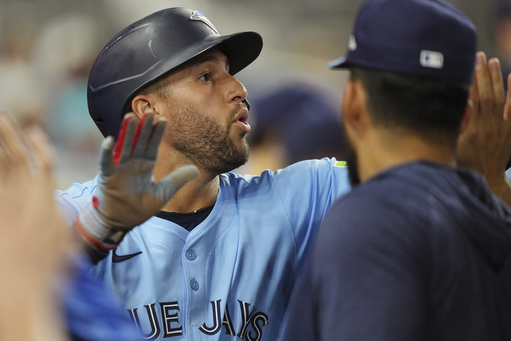 Toronto Blue Jays' George Springer celebrates scoring a run in the 12th inning during a baseball game against the Miami Marlins, Saturday, Aug. 23, 2025, in Miami. (AP Photo/Jim Rassol)
