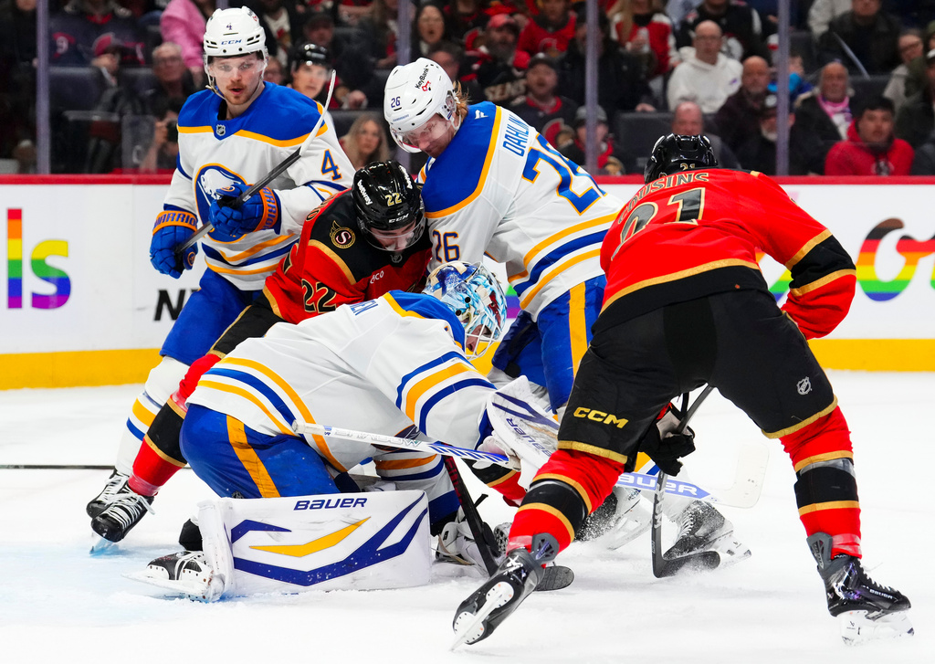 Buffalo Sabres goaltender Ukko-Pekka Luukkonen, bottom left, covers the puck as teammate Rasmus Dahlin (26) tries to push away Ottawa Senators' Michael Amadio (22) during second-period NHL hockey game action in Ottawa, Ontario, Thursday, April 2, 2026. (Sean Kilpatrick/The Canadian Press via AP)