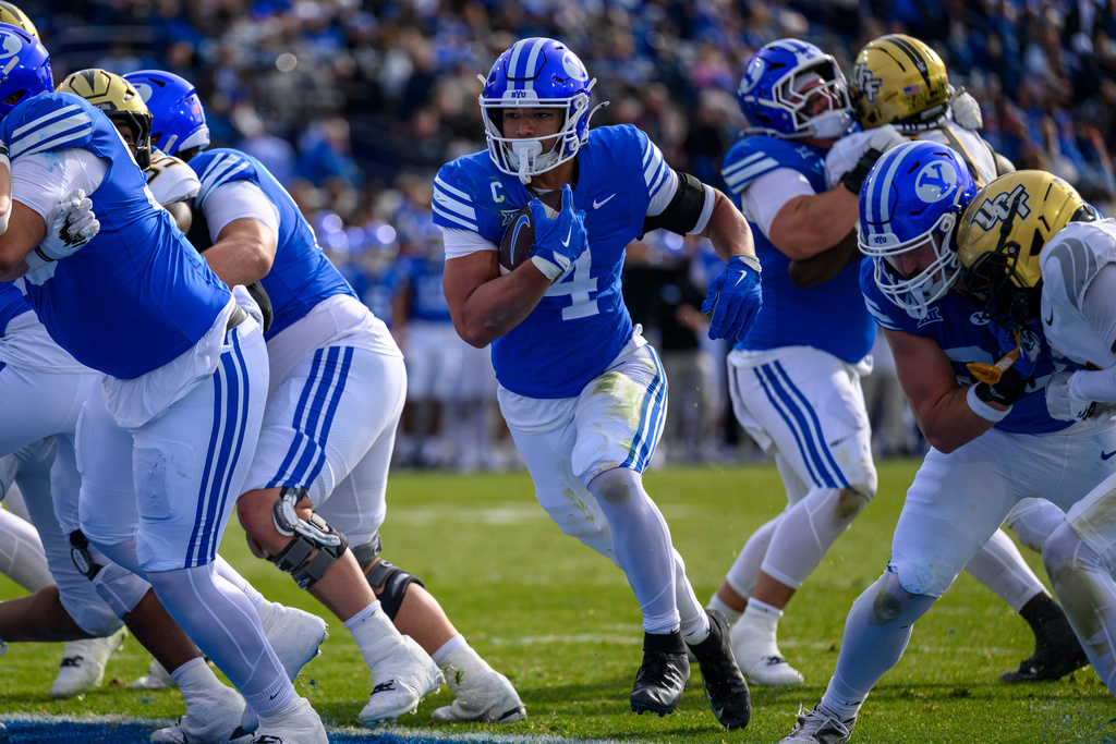 BYU running back LJ Martin (4) runs the ball in for a touchdown during the first half an NCAA college football game, Saturday, Nov. 29, 2025, in Provo, Utah. (AP Photo/Tyler Tate)