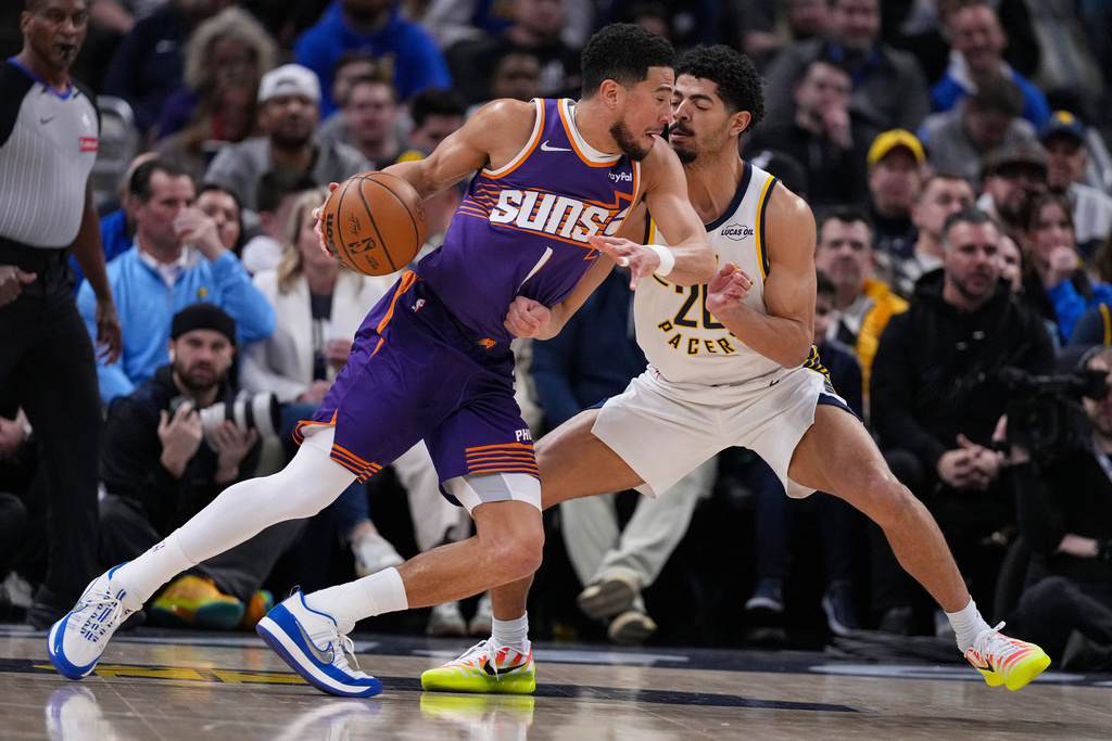 Phoenix Suns guard Devin Booker (1) drives on Indiana Pacers guard Ben Sheppard (26) during the first half of an NBA basketball game in Indianapolis, Thursday, March 12, 2026. (AP Photo/Michael Conroy)