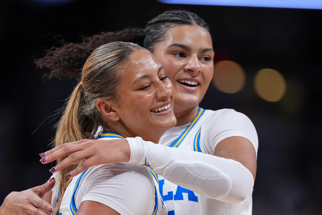 UCLA center Lauren Betts, right, hugs forward Sienna Betts (16) as Iowas called a time out in the first half of an NCAA college basketball game in the finals of the Big Ten Conference tournament, Sunday, March 8, 2026 in Indianapolis. (AP Photo/Michael Conroy)