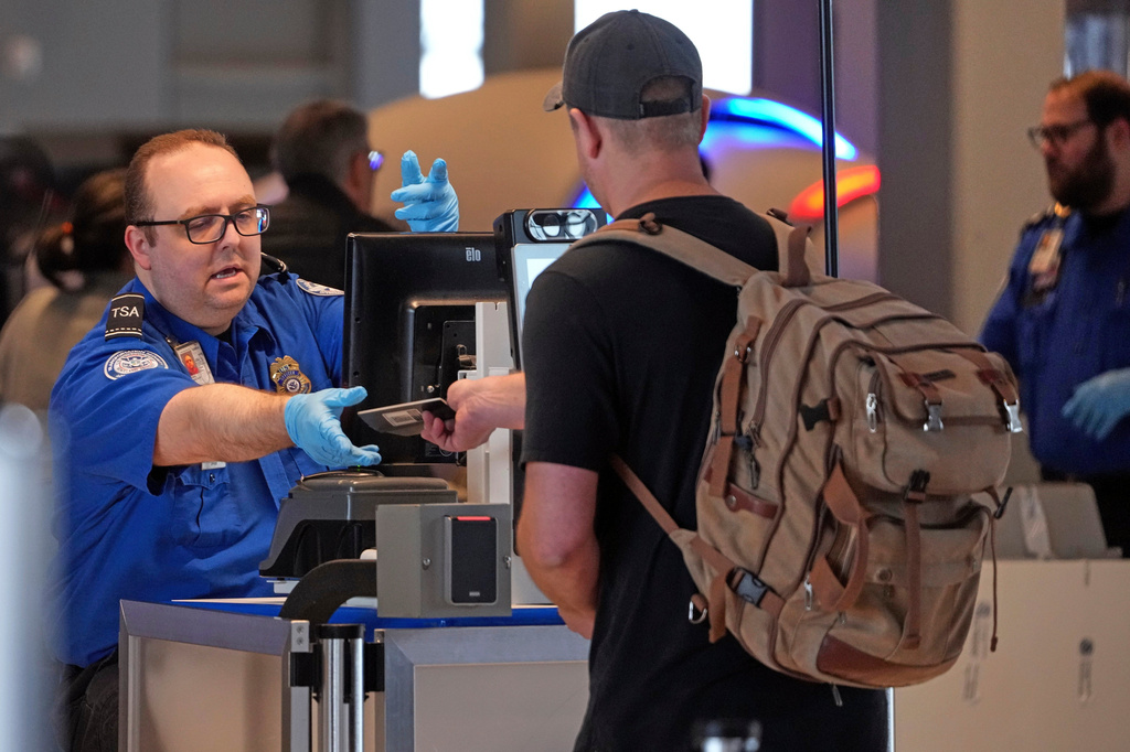 FILE - A Transportation Security Administration worker hands a passport back to a traveler at a TSA checkpoint at Pittsburgh International Airport in Imperial, Pa., March 23, 2026. (AP Photo/Gene J. Puskar, File)