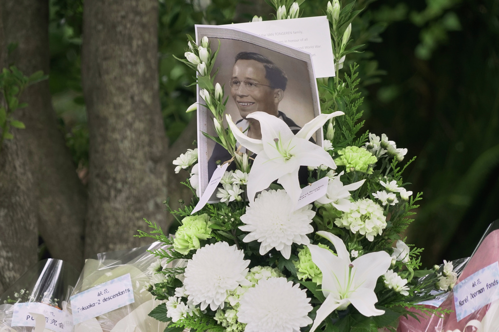 The portrait of a Dutch soldier who was held in wartime prison camps in Nagasaki, is placed by flowers during a ceremony for the victims of the Fukuoka POW Camp No. 2 in Koyagi, Nagasaki city, western Japan, Saturday, Sept. 13, 2025. (AP Photo/Mayuko Ono)