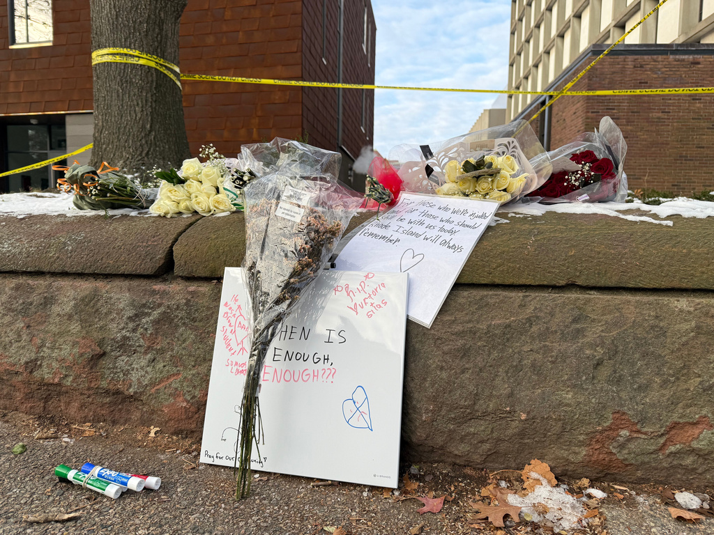 A memorial of flowers and signs lay outside the Barus and Holley engineering building at Brown University, on Hope Street in Providence, R.I., on Tuesday, Dec 16, 2025. (AP Photo/Matt OBrien)