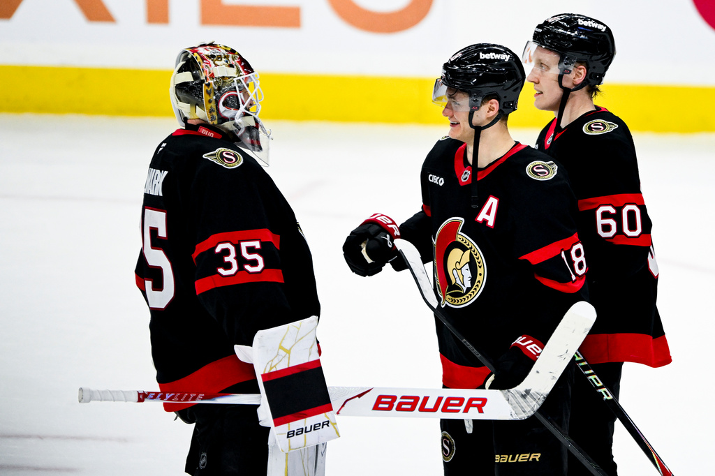 Ottawa Senators goaltender Linus Ullmark (35) celebrates with teammate Tim Stützle (18) after their team's win over the Carolina Hurricanes in an NHL hockey game in Ottawa, Ontario, on Sunday, April 5, 2026. (Spencer Colby/The Canadian Press via AP)