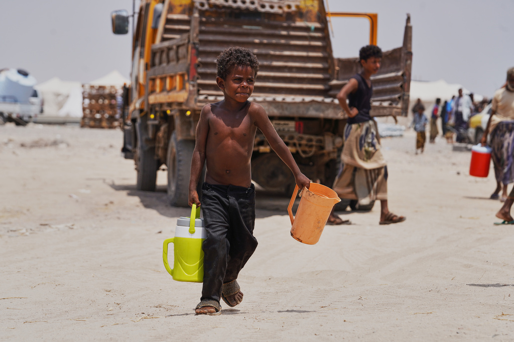 A displaced Yemeni boy carries water containers at Al-Firdaws camp in Ras Imran, on the western outskirts of Aden, Yemen, Tuesday, Sept. 29, 2026. (AP Photo/Abdulnasser Alseddik)