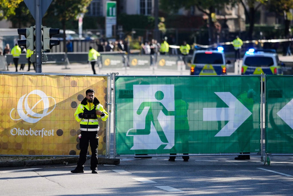 A man stands at the fence of the Oktoberfest area that stays closed after a bomb threatening in Munich, Germany, Wednesday, Oct.1, 2025. (AP Photo/Matthias Schrader)