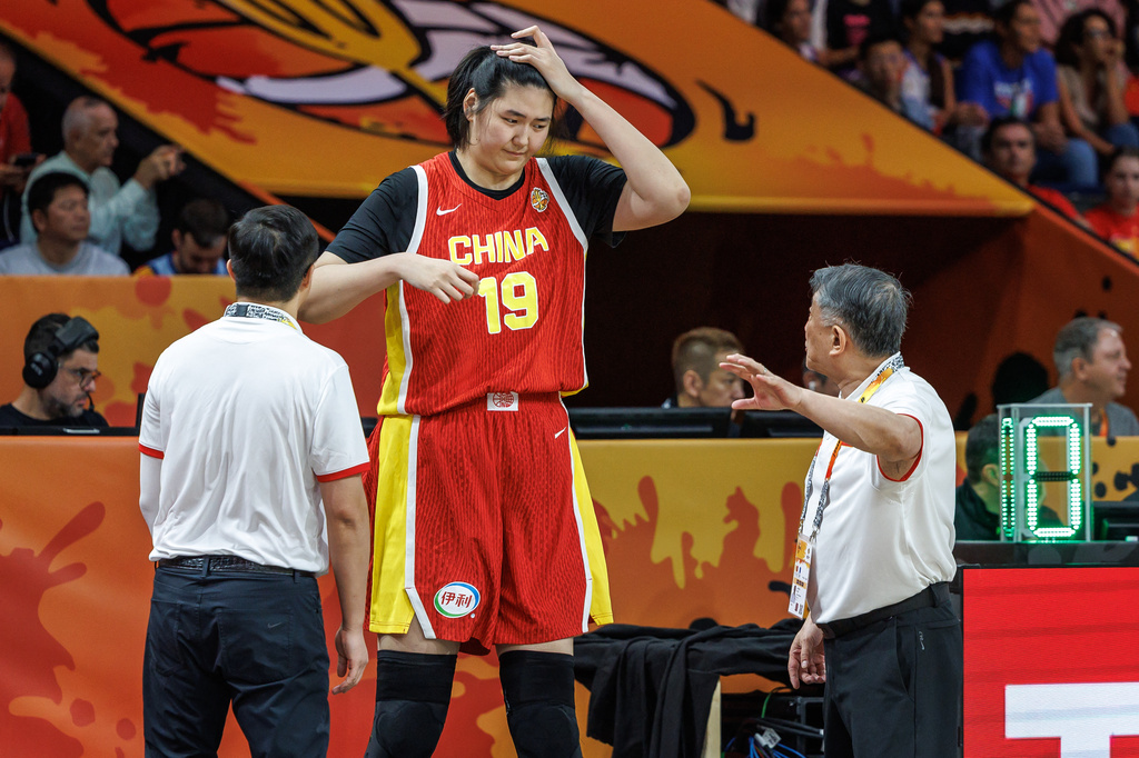 China's Zhang Ziyu, center, and China's head Coach Gong Luming, right, talk during the women's World Cup basketball match between Italy and China, in Berlin, Germany, Monday, Sept. 7, 2026. (Andreas Gora/dpa via AP)