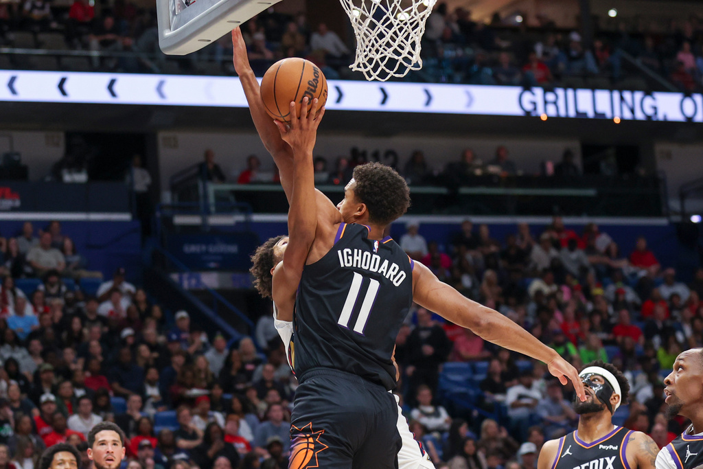 New Orleans Pelicans guard Jordan Poole, center left, goes up to shoots a layup against Phoenix Suns forward Oso Ighodaro (11) in the first half of an NBA basketball game Friday, Dec. 26, 2025, in New Orleans. (AP Photo/Peter Forest)