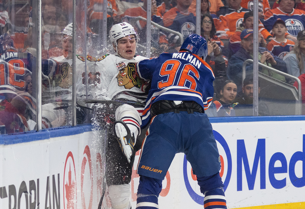 Chicago Blackhawks' Anton Frondell (16) is checked by Edmonton Oilers' Jake Walman (96) during the first period of an NHL hockey game in Edmonton, Alberta, on Thursday April 2, 2026. (Jason Franson/The Canadian Press via AP)