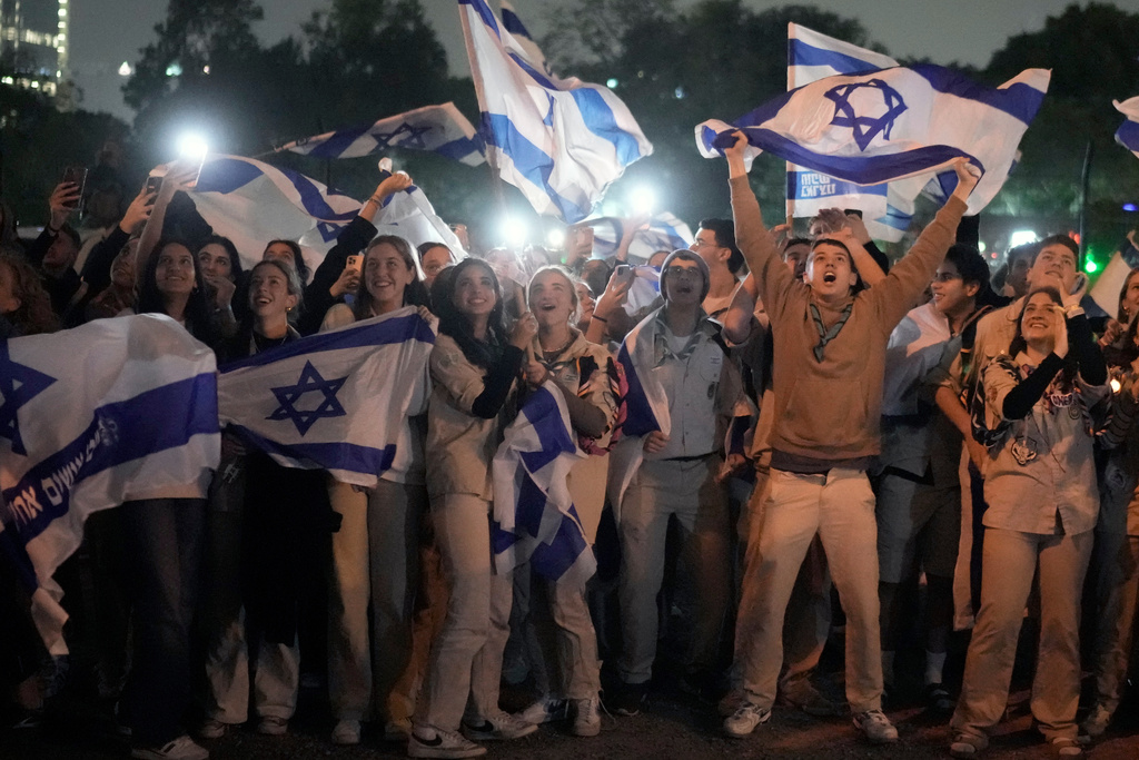 People celebrate as a helicopter carrying hostages released from the Gaza Strip lands at the Schneider Children's Medical Center in Petah Tikva, Israel, Sunday Nov. 26, 2023. (AP Photo/Leo Correa)