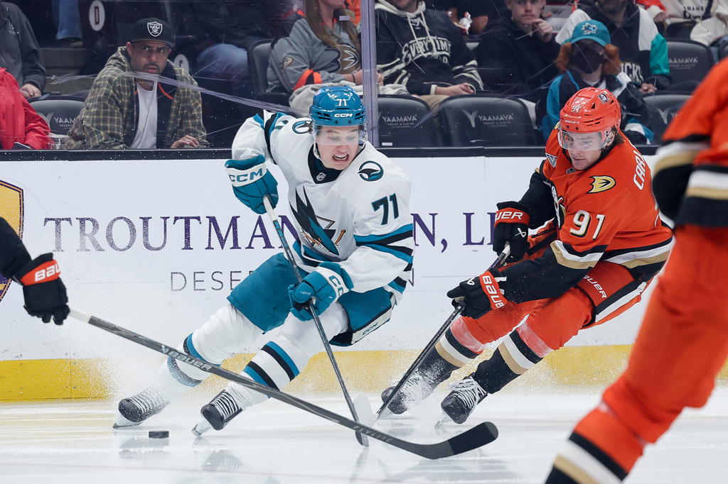 San Jose Sharks center Macklin Celebrini, left, moves the puck against Anaheim Ducks center Leo Carlsson during the second period of an NHL hockey game Thursday, April 9, 2026 in Anaheim, Calif. (AP Photo/Ryan Sun)