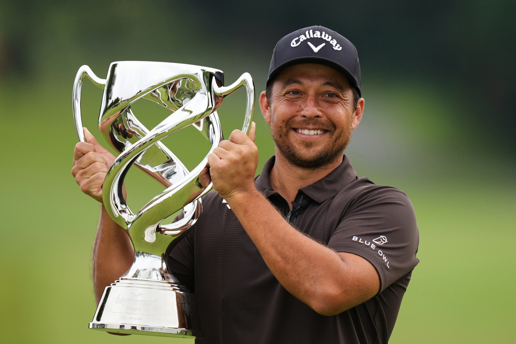 Xander Schauﬀele, of the U.S., poses for a photo with his trophy after he won the Baycurrent Classic golf tournament at the Yokohama Country Club in Yokohama, near Tokyo, Sunday, Oct. 12, 2025. (AP Photo/Hiro Komae)