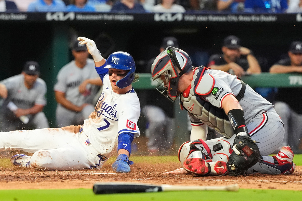 Kansas City Royals' Bobby Witt Jr. (7) beats the tag by Minnesota Twins catcher Ryan Jeffers to score on a fielder's choice hit into by Jac Caglianone during the fifth inning of a baseball game Tuesday, Aug. 4, 2026, in Kansas City, Mo. (AP Photo/Charlie Riedel)