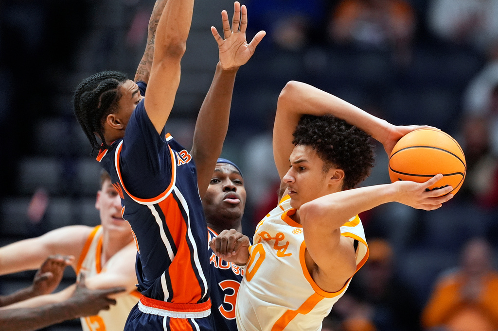 FILE - Tennessee forward Nate Ament, right, is defended by Auburn guard Elyjah Freeman, left, and forward Sebastian Williams-Adams, middle, during the first half of an NCAA college basketball game in the second round of the Southeastern Conference tournament, March 12, 2026, in Nashville, Tenn. (AP Photo/George Walker IV, File)