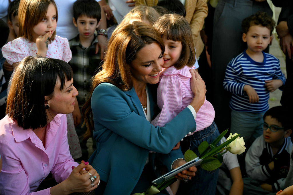 Britain's Kate, Princess of Wales, center, hugs a child during her visit to the Scuola Comunale d'infanzia Anna Frank, a municipal pre-school for 3 – 6-year-olds, part of a two-day trip, in Reggio Emilia, Italy, Wednesday, May 13, 2026. (Marco Bertorello/Pool Photo via AP)