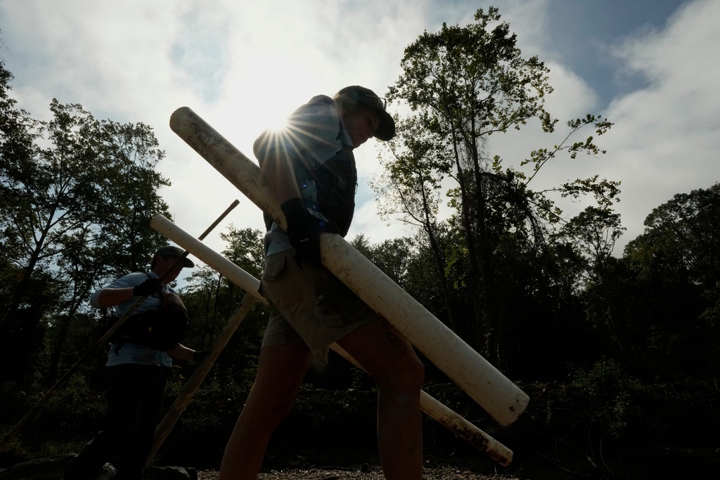 Leslie Beninato, river cleanup logistics manager of MountainTrue, removes a PVC pipe from the French Broad River on Wednesday, Sept. 17, 2025, in Asheville, N.C. (AP Photo/Chris Carlson)