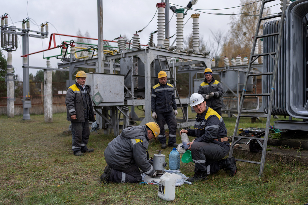 CORRECTS FAMILY NAME TO ADAMCHUK - Oleksandr Adamchuk, 36, a repair and maintenance master for DTEK, second from right, does scheduled repair work on an energy substation with his brigade, from left, Rostyslav Yashchuk, Roman Gerasymchuk, Andriy Korniychuk and Igor Kryvenko, Friday, Oct. 24, 2025, in Kyiv region, Ukraine. (AP Photo/Julia Demaree Nikhinson)