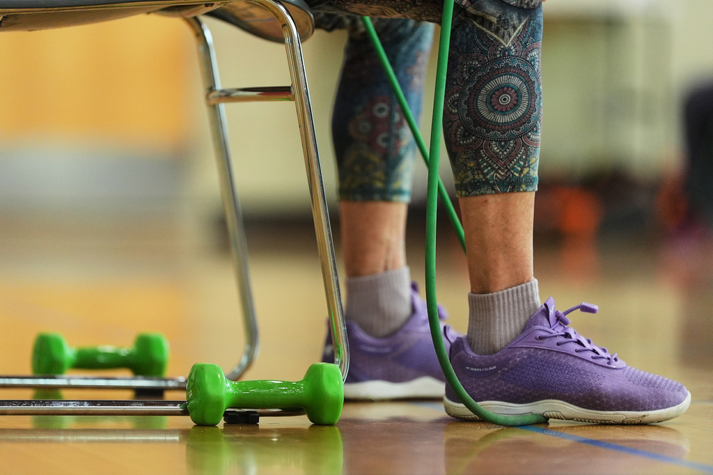 A participant uses an exercise band during a class for older adults led by instructor Bengie Santos at the Dale Turner Family YMCA, April 30, 2026, in Shoreline, Wash. (AP Photo/Lindsey Wasson)