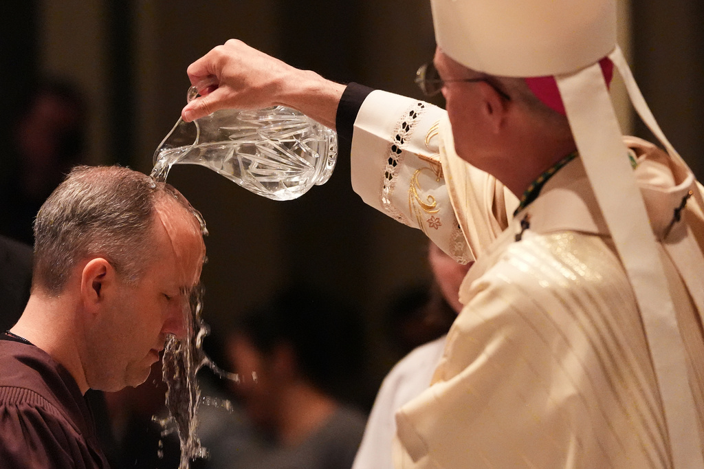 Archbishop Paul D. Etienne baptizes a candidate during an Easter vigil at St. James Cathedral, Saturday, April 4, 2026, in Seattle. (AP Photo/Lindsey Wasson)