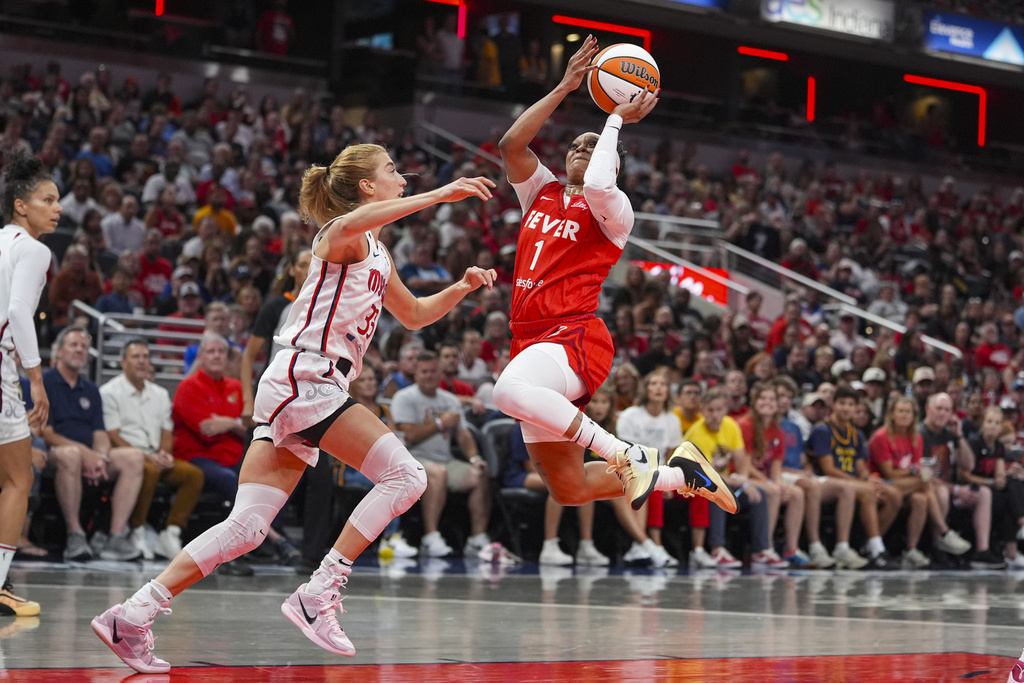 Indiana Fever guard Odyssey Sims (1) shoots over Washington Mystics guard Lucy Olsen (33) in the first half of a WNBA basketball game in Indianapolis, Friday, Aug. 15, 2025. (AP Photo/Michael Conroy)