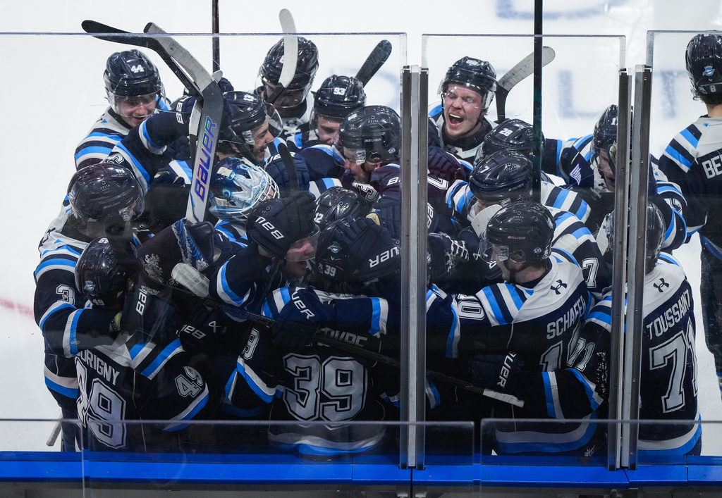 Chicoutimi Sagueneens' Liam Lefebvre (39) is mobbed by his teammates after scoring the winning goal during the first overtime period of a Memorial Cup hockey game against the Kelowna Rockets in Kelowna, British Columbia, Sunday, May 24, 2026. (Darryl Dyck/The Canadian Press via AP)