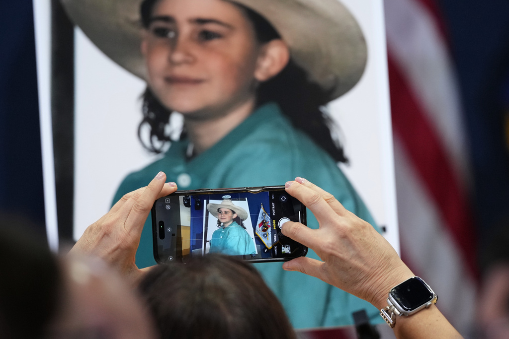 A family member records a photo of victim Amy Ayers during a news conference regarding a breakthrough in the 1991 I Can't Believe It's Yogurt murder case, Monday, Sept. 29, 2025, in Austin, Texas. (AP Photo/Eric Gay)