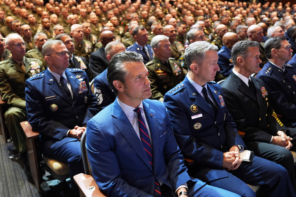 FILE - Defense Secretary Pete Hegseth, left front, Chairman of the Joint Chiefs of Staff Air Force Gen. Dan Caine, third from right, and U.S. military senior leadership listen to President Donald Trump speak at Marine Corps Base in Quantico, Va., Sept. 30, 2025. (AP Photo/Evan Vucci, File)