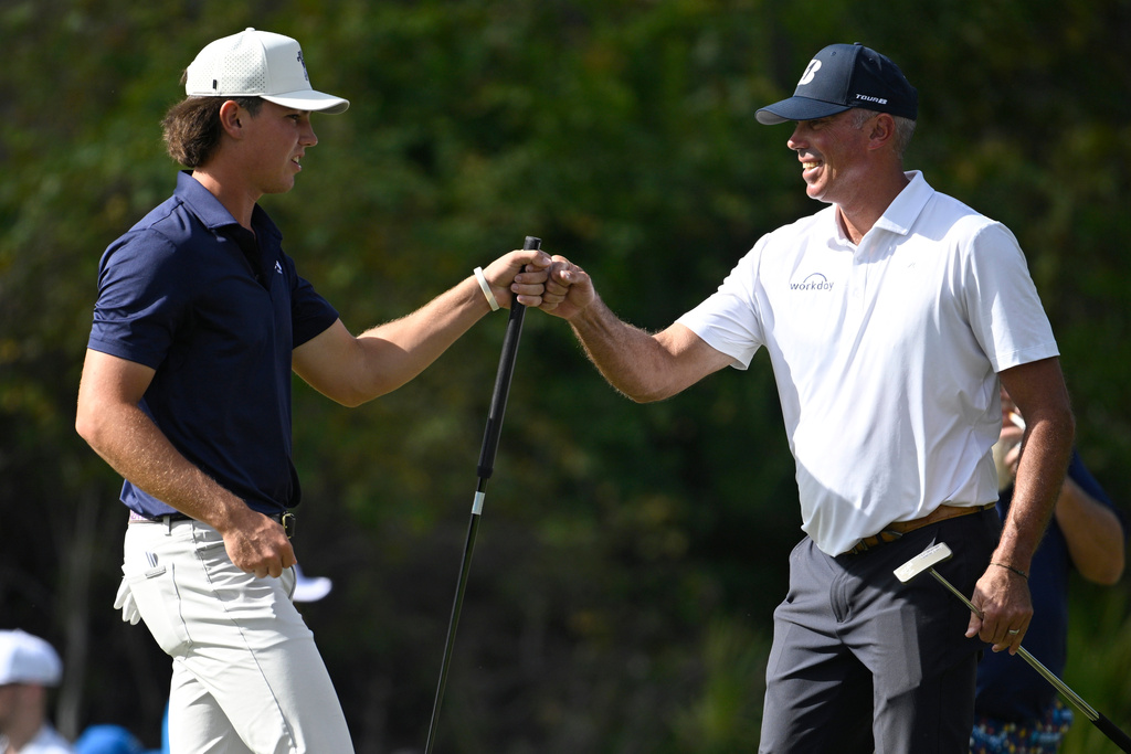 Matt Kuchar, right, gets a fist bump from his son Cameron Kuchar after sinking an eagle putt on the third green during the final round of the PNC Championship golf tournament, Sunday, Dec. 21, 2025, in Orlando, Fla. (AP Photo/Phelan M. Ebenhack)