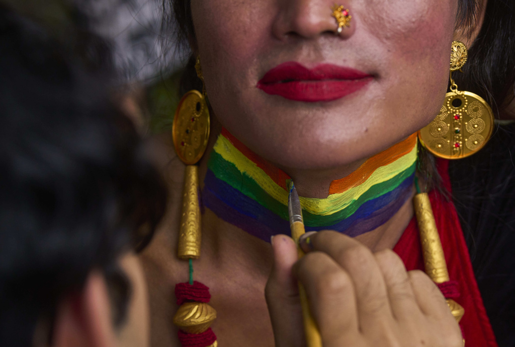 A participant paints her neck with rainbow colors during the Pride Parade in Kathmandu, Nepal, Sunday, Aug. 10, 2025. (AP Photo/Niranjan Shrestha)