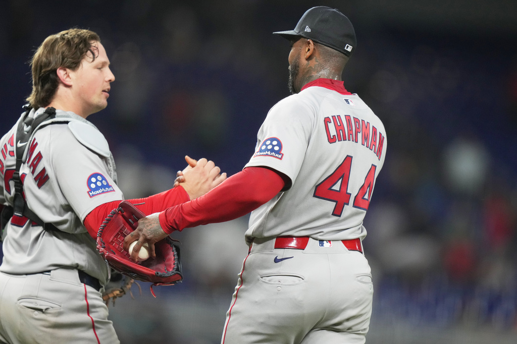 Boston Red Sox catcher Adley Rutschman, left, shakes hands relief pitcher Aroldis Chapman (44) after defeating the Miami Marlins, during the of a baseball game, Monday, Aug. 24, 2026, in Miami. (AP Photo/Lynne Sladky)