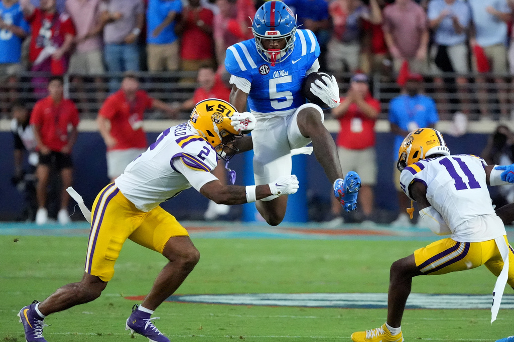 Mississippi running back Kewan Lacy (5) leaps between LSU safety Ty Benefield (2) and cornerback PJ Woodland (11) during the first half of an NCAA college football game in Oxford, Miss., Saturday, Sept. 19, 2026. The play was called back. (AP Photo/Rogelio V. Solis)