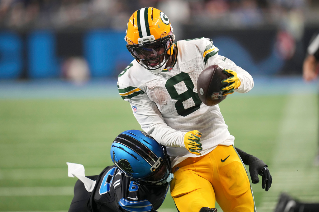 Green Bay Packers running back Josh Jacobs (8) breaks a tackle by Detroit Lions cornerback Keith Abney II (6) during a touchdown reception in the second half of an NFL football game, Sunday, Oct. 25, 2026, in Detroit. (AP Photo/Paul Sancya)