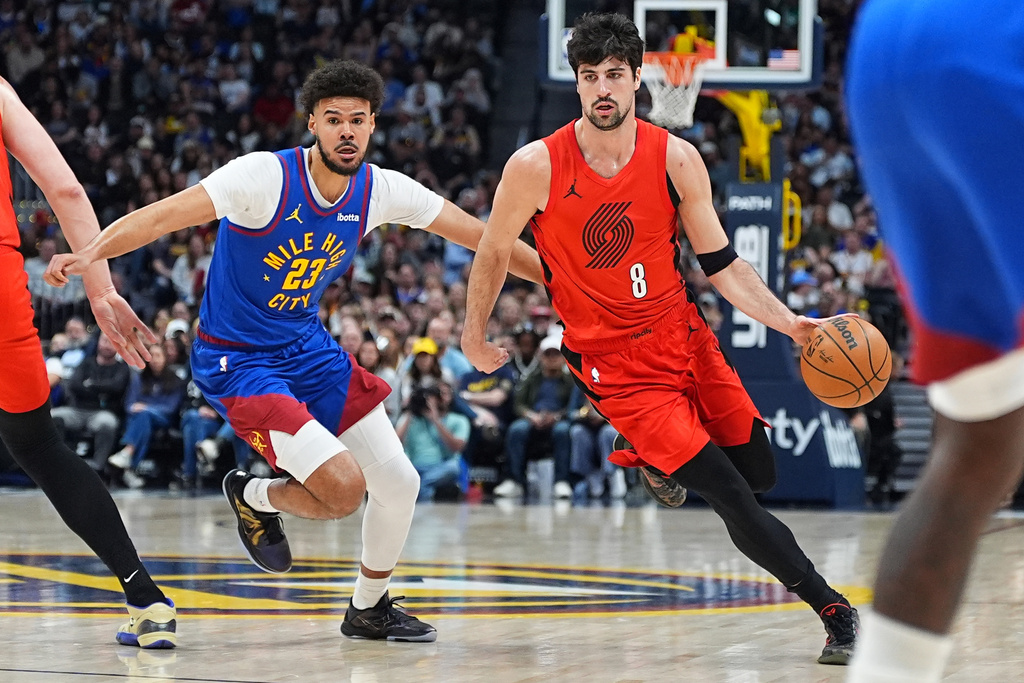 Portland Trail Blazers forward Deni Avdija (8) drives the lane as Denver Nuggets forward Cameron Johnson (23) defends in the first half of an NBA basketball game Sunday, March 22, 2026, in Denver. (AP Photo/David Zalubowski)