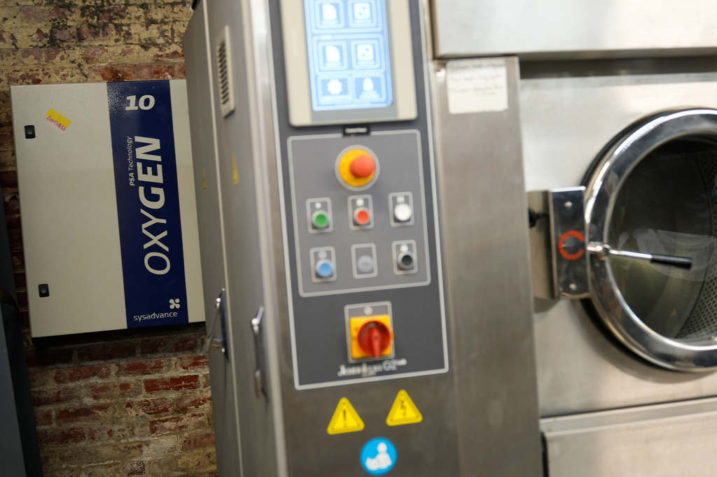 A machine that uses oxygen and ozone in place of water and chemicals to distress clothes is seen at the BPD Washhouse, a denim processing facility, in Jersey City, N.J., Tuesday, May 5, 2026. (AP Photo/Seth Wenig)