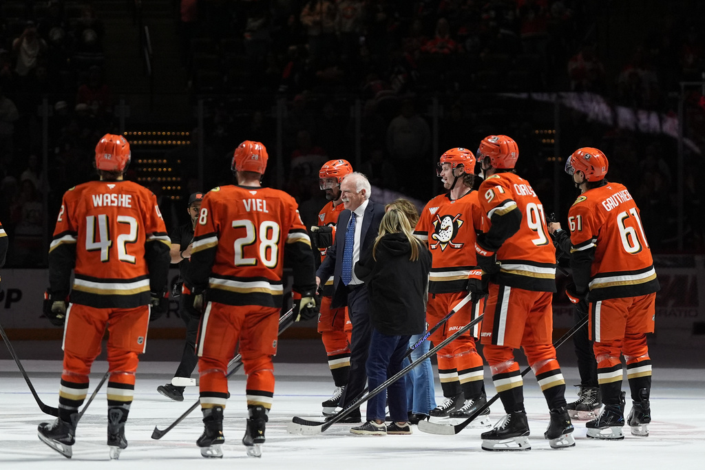Anaheim Ducks head coach Joel Quenneville, center, celebrates with players and family after winning his 1,000th career coaching victory with a 6-4 win over the Edmonton Oilers in an NHL hockey game Wednesday, Feb. 25, 2026, in Anaheim, Calif. (AP Photo/Gregory Bull)