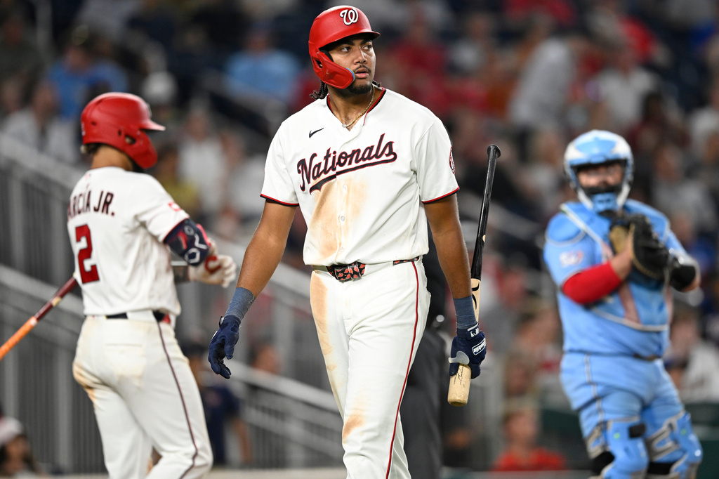 Washington Nationals' James Wood, center, walks back to the dugout after striking out during the seventh inning of a baseball game against the Toronto Blue Jays, Monday, July 27, 2026, in Washington. (AP Photo/John McDonnell)