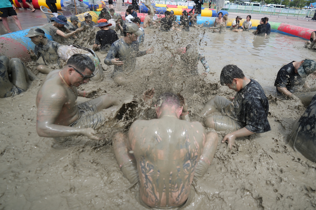 People play in a mud pool during the Boryeong Mud Festival near a beach in Boryeong, South Korea, Saturday, July 25, 2026. (AP Photo/Lee Jin-man)
