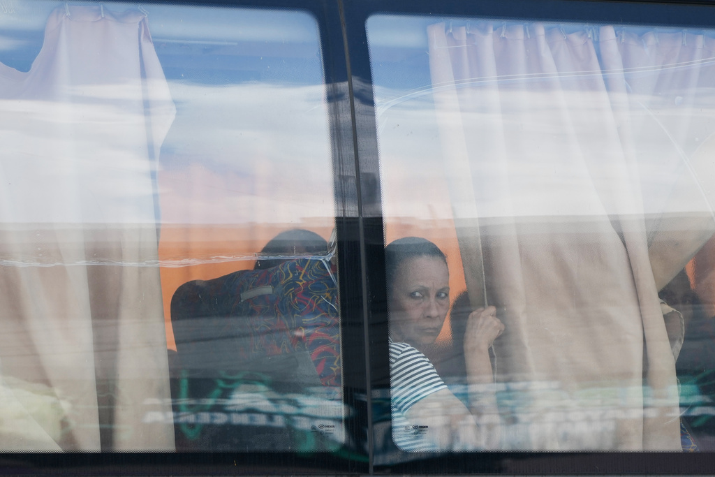 Relatives arrive by bus to the funeral of military killed in the U.S. military operattion to capture former Venezuelan President Nicolas Maduro in Caracas, Venezuela, Wednesday, Jan. 7, 2026. (AP Photo/Ariana Cubillos)